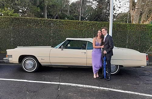 chauffeur rentals for matric balls matric dance couple standing next to cadillac-min