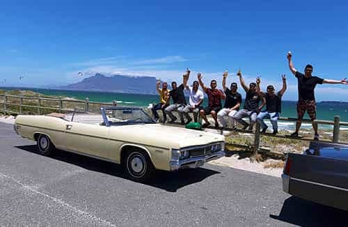 cape corporate tours cadillac tours and transfers guys sitting next to classic convertible cadillacs table mountain in background